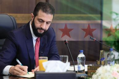 Syrian President Ahmed al-Sharaa places his signature at a cabinet meeting in Damascus, October 12, 2025.