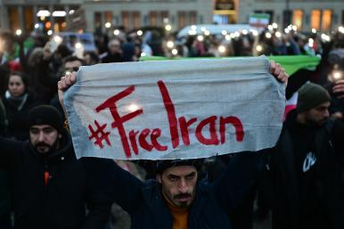 A protester holds a #FreeIran banner in Berlin - source: Reuters