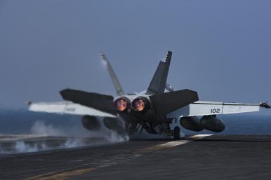 A US Navy F-18 lands on a carrier flight deck - source: Department of Defense
