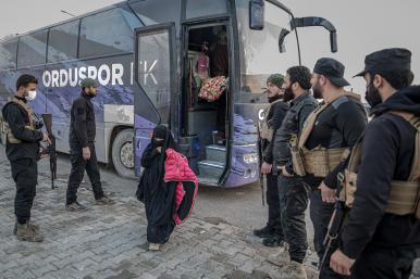 Photo of a girl being transferred from a camp for Islamic-State-affiliated detainees in Syria.