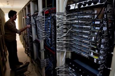 A man manipulates cables on a bank of internet data servers - source: Reuters