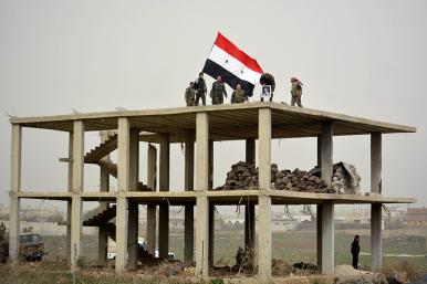 Syrian flag over a ruined building destroyed by bombing