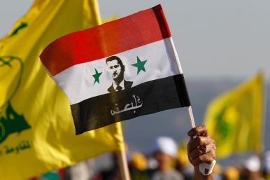 Protesters hold Syrian and Hezbollah flags