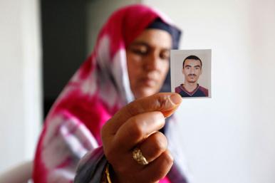 A Tunisian woman holds a photo of a relative who joined a jihadist movement