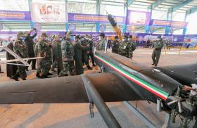 Iranian military leaders inspect drones.