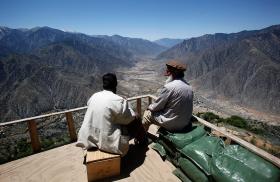 Afghan militia fighters survey a valley in Kunar province