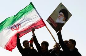 Protesters wave the Iranian flag and a photo of Iran's supreme leader Ali Khamenei