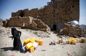 A Yemeni woman at a ruined building in Hodeidah