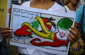 A Lebanese protester holds a sign denouncing Iranian influence