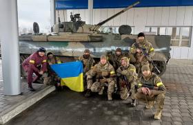 Ukrainian soldiers pose with a captured Russian military vehicle - source: Reuters