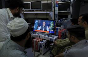 Pakistani men watch a televised address by Prime Minister Imran Khan on March 31, 2022 - source: Reuters