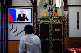A man watches Russian president Vladimir Putin speak on television in the Crimean city of Simferopol - source: Reuters