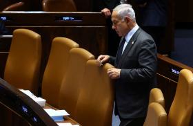 Photo of Israeli prime minister Binyamin Netanyahu standing alone in parliament.