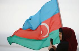An Azeri woman with an Azerbaijan flag in the Nogorno-Karaback region of Armenia - source: Reuters