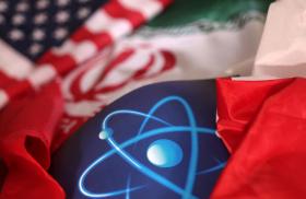 A photo illustration shows US and Iranian flags and an atomic symbol - source: Reuters