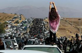 Twitter photo showing an Iranian woman standing on top of a car during a protest against the killing of Mahsa Amini.