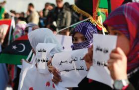 Protesters hold signs and flags in Libya - source: Reuters