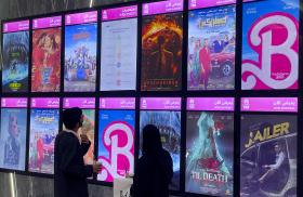 Moviegoers look at posters and showtimes at a theater in Riyadh, Saudi Arabia in August 2023, including the global hit "Barbie" - source: Reuters