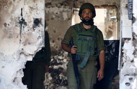 Photo of an Israeli soldier in the ruins of a kibbutz following the October 2023 Hamas attack.