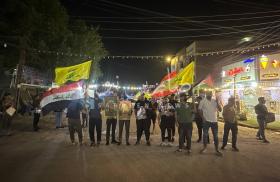 Protestors carrying Iraqi, Lebanon, and KH flags