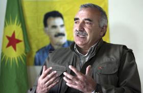 Karayilan, acting military commander of the PKK, speaks during an interview with Reuters at the Qandil mountains in Sulaimaniya in 2013, in front of a portrait of jailed PKK leader Abdullah Ocalan - source: Reuters