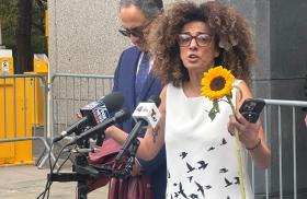 Iranian dissident Masih Alinejad speaks addresses a crowd at a courthouse - source: Holly Dagres