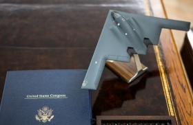 A model of a B-2 stealth bomber sits next to legislation on the president's Oval Office desk - source: The White House