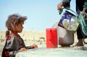 An Iranian girl watches water being poured - source: Reuters