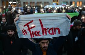 A protester holds a #FreeIran banner in Berlin - source: Reuters