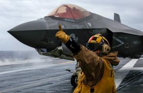 A flight deck crewman directs operations of an F-35 jet on board the USS Abraham Lincoln - source: Department of Defense