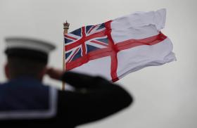 A British sailor salutes the Royal Navy flag - source: Department of Defense