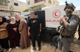 Palestinain refugees wait for IDF permission to gather their belongings while benig expelled from a camp near Jenin - source: Reuters