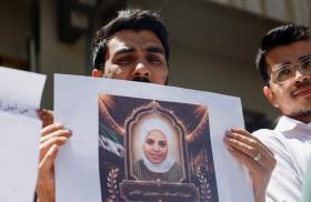 Photo of Syrians holding a memorial protest for family members killed by the former Assad regime.