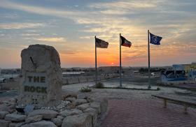 The sun sets behind U.S. and Kuwaiti flags at Ali Al Salem AFB in Kuwait - source: Department of Defense