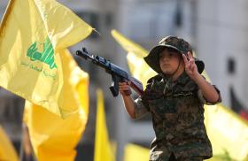 A child marches in a Hezbollah parade, holding a toy gun - source: Reuters