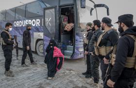 Photo of a girl being transferred from a camp for Islamic-State-affiliated detainees in Syria.