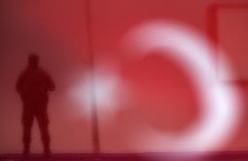 A Turkish soldier stands guard at a rally. Image source: Reuters