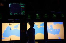 A US Navy sailor stands in front of a map display of the Mediterranean Sea - source: Reuters